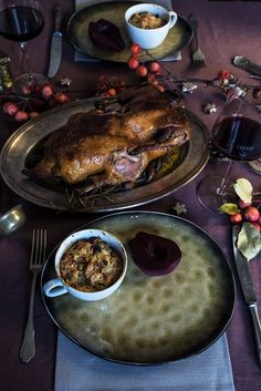 a table topped with two plates filled with food and wine glasses next to each other