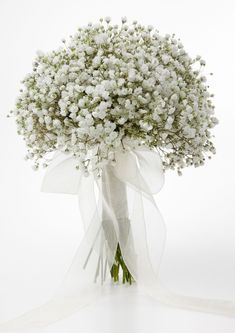 a bunch of flowers that are sitting in a vase on a table with ribbon around it