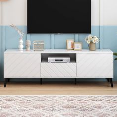 a flat screen tv sitting on top of a white cabinet