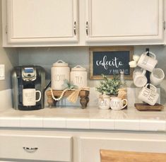 a kitchen counter with coffee cups, mugs and other items sitting on top of it