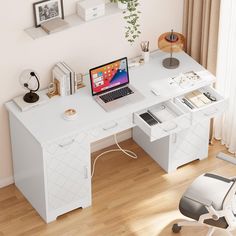 a laptop computer sitting on top of a white desk next to a chair and window