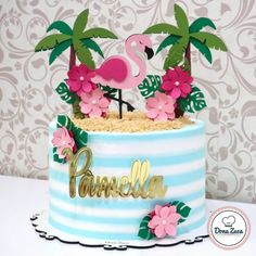 a cake decorated with palm trees, flowers and a flamingo on top is shown