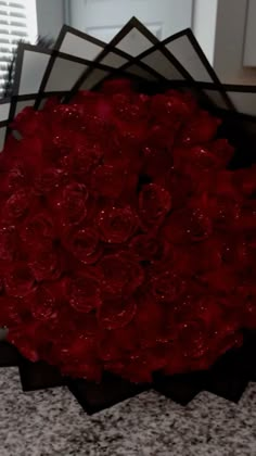 a bouquet of red roses sitting on top of a counter