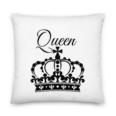 a white pillow with the word queen on it and a black crown in front of it