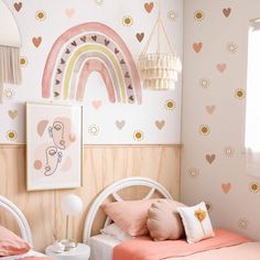 two twin beds in a girls'bedroom decorated with hearts and rainbows on the wall