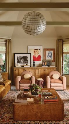 a living room with two couches, a coffee table and pictures on the wall