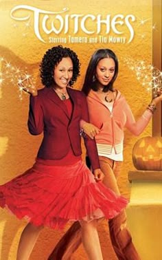 two women standing next to each other in front of a yellow wall with the words witches on it