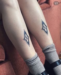 two legs with tattoos on them sitting next to each other