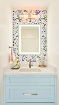 a bathroom vanity with blue drawers and a mirror