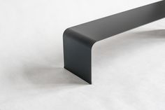 a black bench sitting on top of a white floor