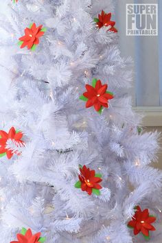 a white christmas tree decorated with poinsettis