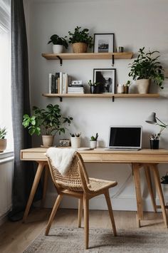 a wooden desk topped with a laptop computer sitting next to a plant filled wall mounted above it