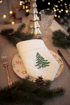 a place setting with pine tree napkins and silverware