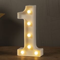 a white light up number one sitting on top of a wooden table