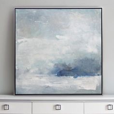 an abstract painting hangs on the wall above a dresser