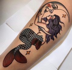 a woman's arm with a mermaid tattoo on it