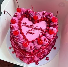 a heart shaped cake with cherries on it in a white box that says happy valentine's day