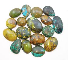 several different types of stones on a white surface with blue, green and yellow speckles