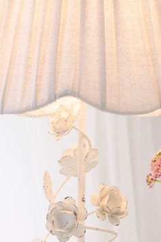 a table lamp with flowers on it next to a flower vase