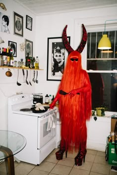 a red devil is standing in the kitchen