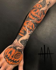 a hand with an orange and black tattoo on it