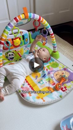 a baby laying on top of a play mat