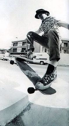 a young man riding a skateboard up the side of a ramp in a parking lot