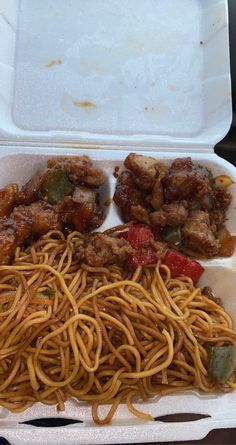 an open takeout box with noodles and meats in sauce on the side is shown