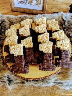 there are many pieces of brown and white cake on the plate with marshmallows