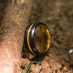 a black and gold ring sitting on top of a tree