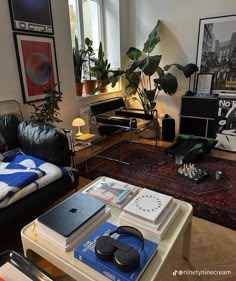 a living room filled with furniture and lots of plants on top of a coffee table