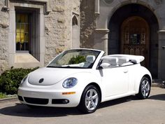 a white convertible car parked in front of a building