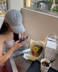 a woman sitting at a table looking at her cell phone