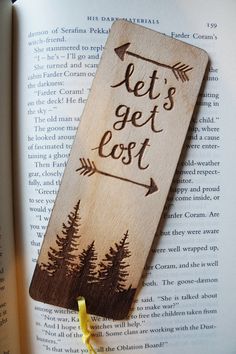 a wooden bookmark with the words let's get lost on it