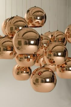 many shiny balls hanging from the ceiling in front of a mirror ball chandelier