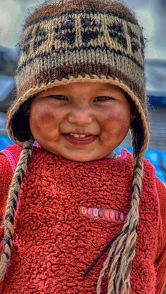 a young child wearing a knitted hat and smiling