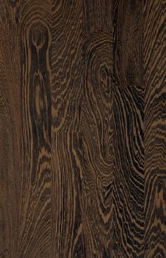 closeup of wood grains on the surface of a wooden flooring paneled in brown and black