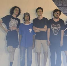 five young men standing in front of a white wall