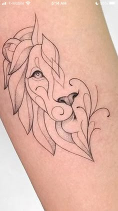 a tattoo on the leg of a woman with a lion's head and leaves