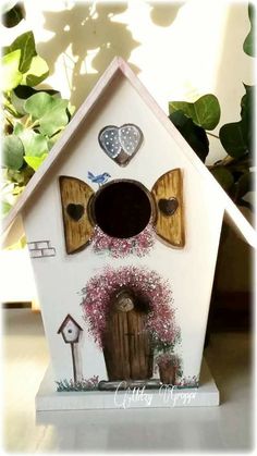 a bird house with hearts and flowers painted on it