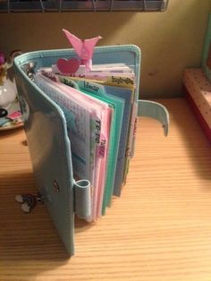 there is a wallet that has many cards in it and a pink bird sticking out of the pocket