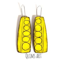 two yellow earrings with circles on them and the words olims art written below