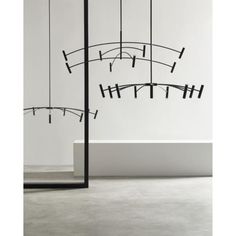 an artistic sculpture in the middle of a room with white walls and black metal poles