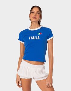 This Trendy T-Shirt Will Have You Repping Italy Like You're A Local. With It's Perfect Fit And Cute Contrast Detailing, It's A Great Option For A Casual Comfy Fit. T-Shirt. Graphic Print. Contrast Sleeves & Neckline. 95% Cotton, 5% Spandex. Model Wears Size S. Model Height Is 5'7. Item Care: Wash With Similar Color. | Edikted Italy Tee Wwe T Shirts, Flannel Sweatshirt, Girls Graphic Tee, Flannel Jacket, Basic Fits, Girls Blouse, Open Knit Sweater, Top Graphic Tees, Sweaters And Jeans