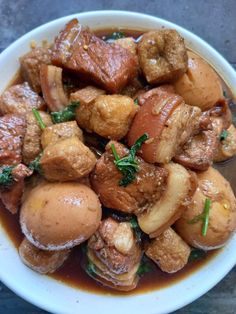 a white bowl filled with meat and vegetables