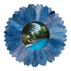 a blue flower shaped mirror with a pool in the middle and palm trees around it