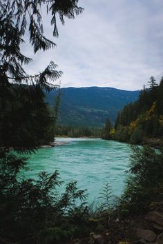 the water is very blue and green in this photo, with mountains in the background