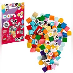 a pile of colorful legos next to a bag of stickers on a white background