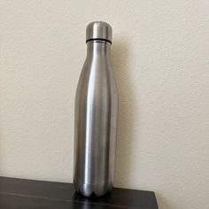 a stainless steel bottle sitting on top of a shelf