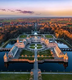 an aerial view of the palace and gardens at sunset, with trees in the foreground